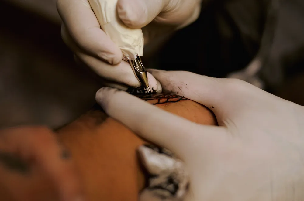 A close view of a hand tool placing pigment into skin